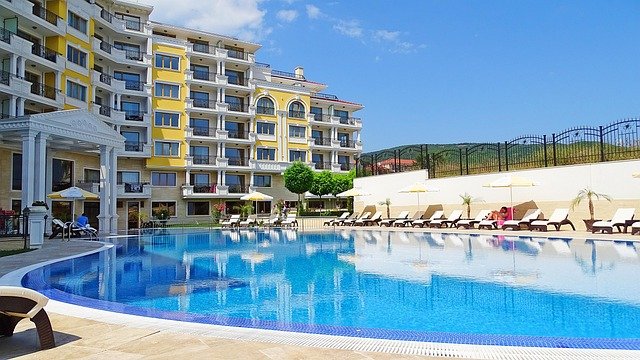 Área de lazer de uma associação de moradores, mostrando uma piscina e, ao fundo, os prédios que compõem o complexo